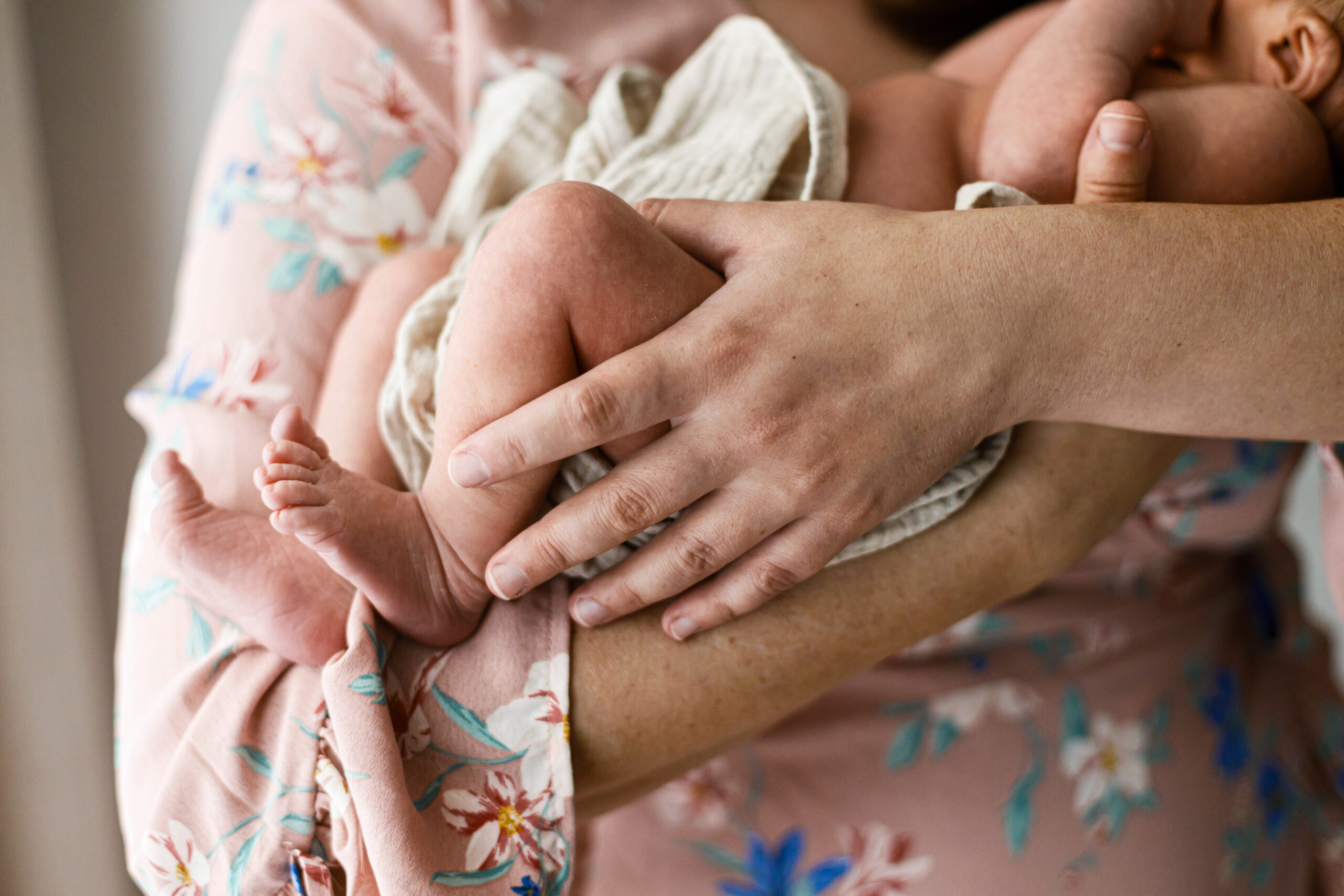 Happy Mothers day! Newborn little feet close up in mothers hands. Mother hugging cute baby. Motherhood and parenthood. Adoption and fertility concept